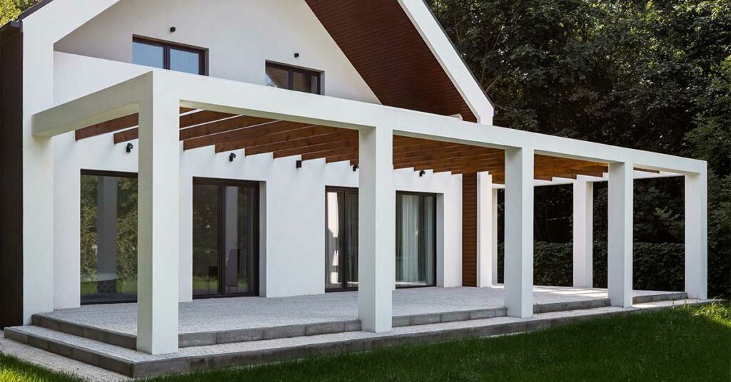 Eine Terrasse mit weißer Pergola und Garten - Immobilienkauf