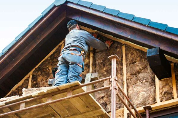 Handwerker beim Dämmen des Hauses.